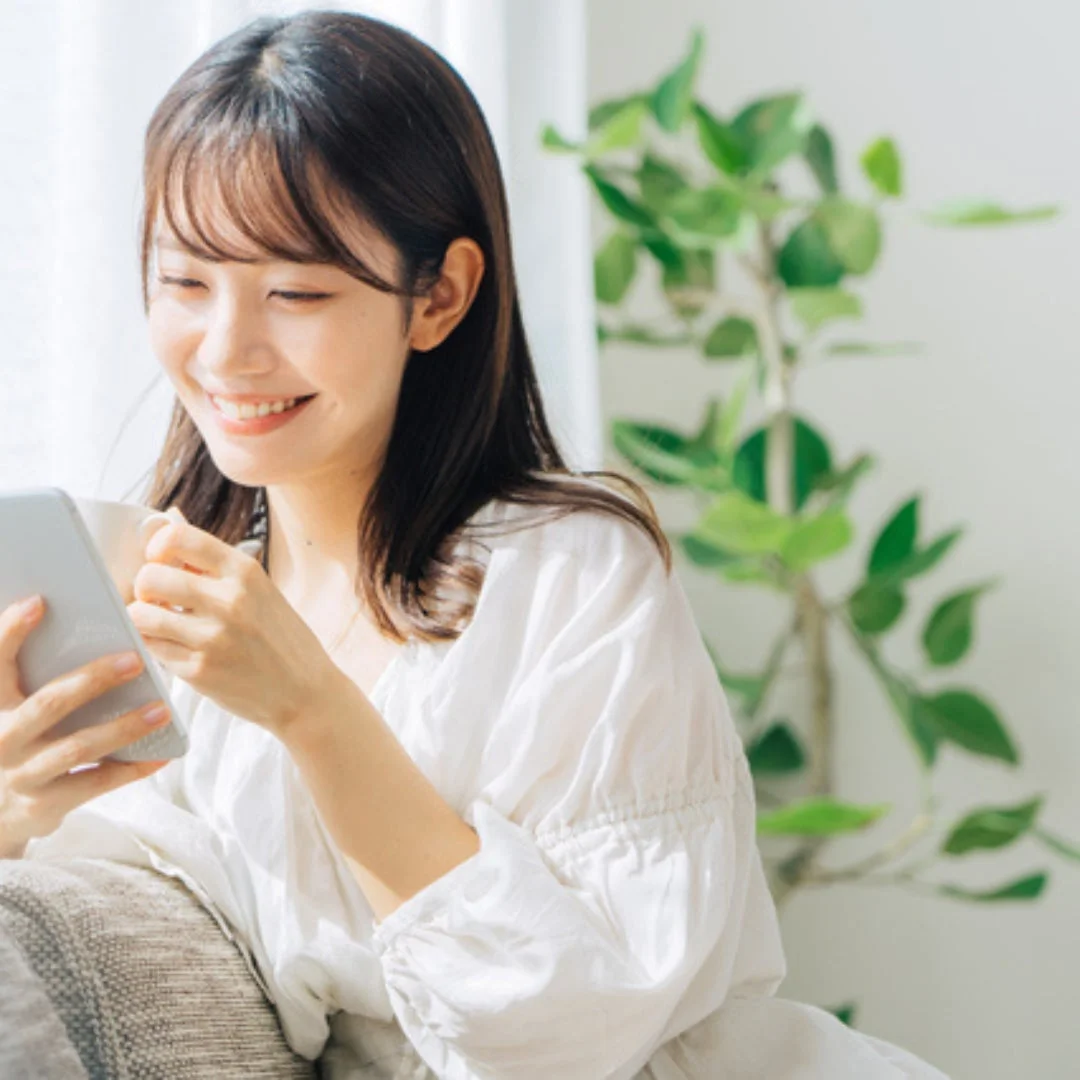 女性が自宅でスマートフォンを操作している