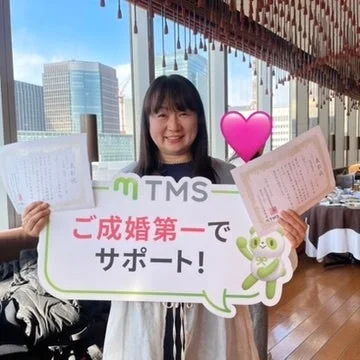 笑顔の女性が看板を持つ