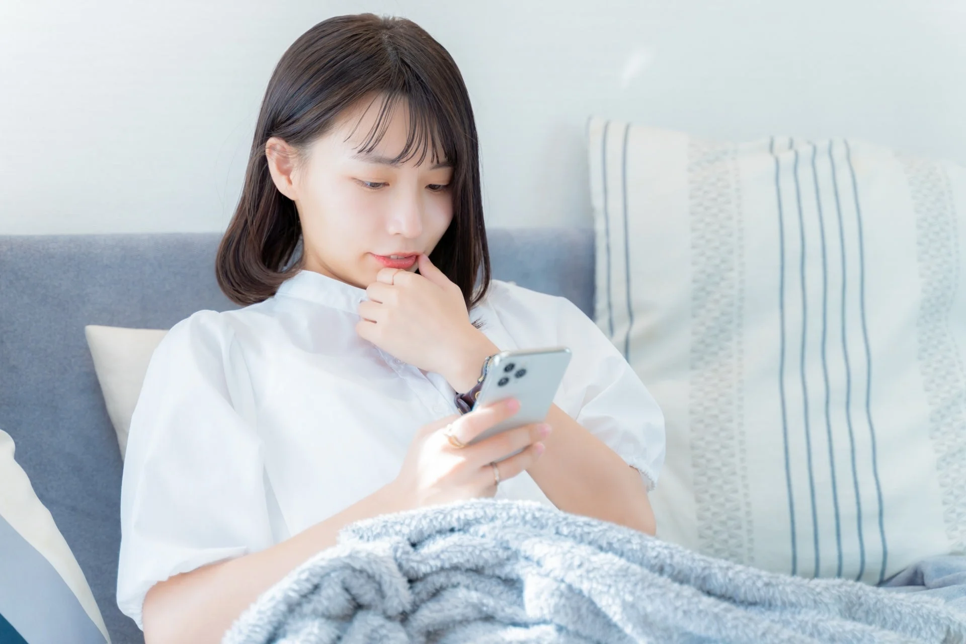 ソファでスマホを操作する女性