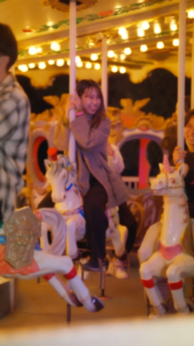 メリーゴーランドに乗る女性