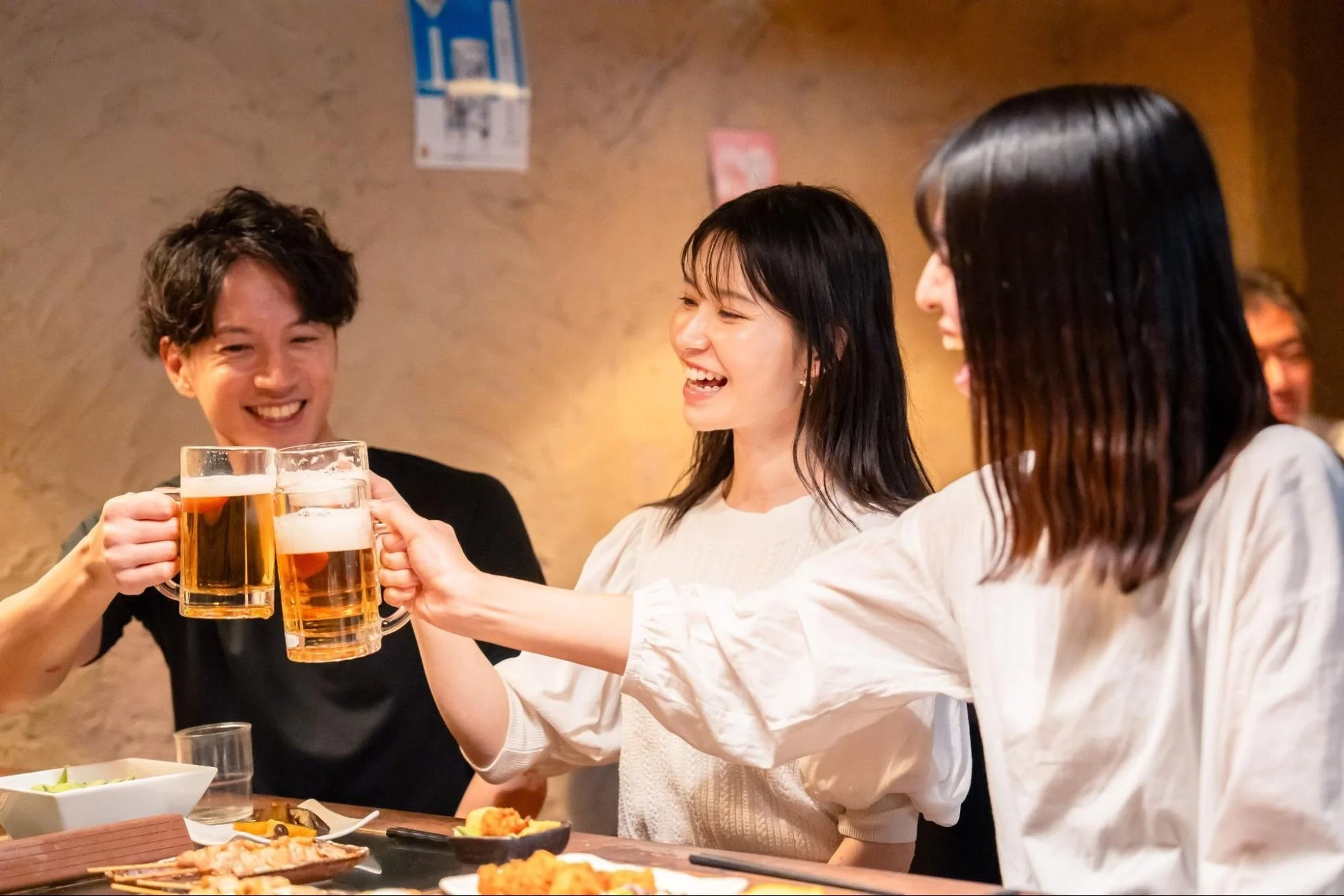 飲み会で乾杯する男女の様子