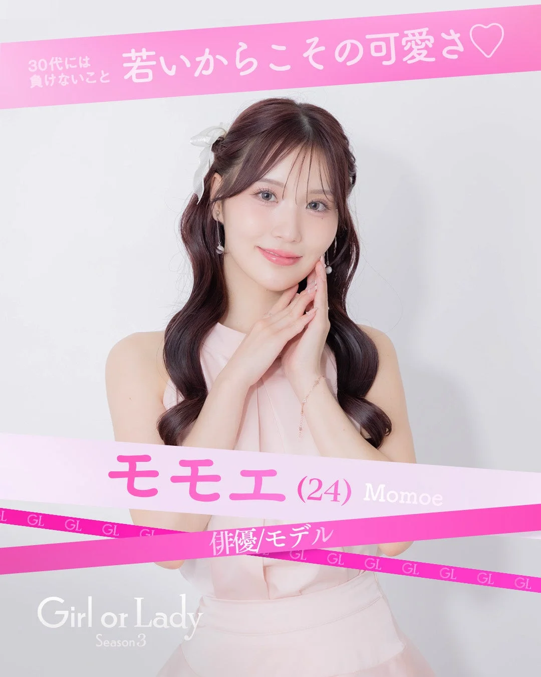 ピンクのリボンが特徴的な背景で微笑む俳優/モデルのモモエさん
